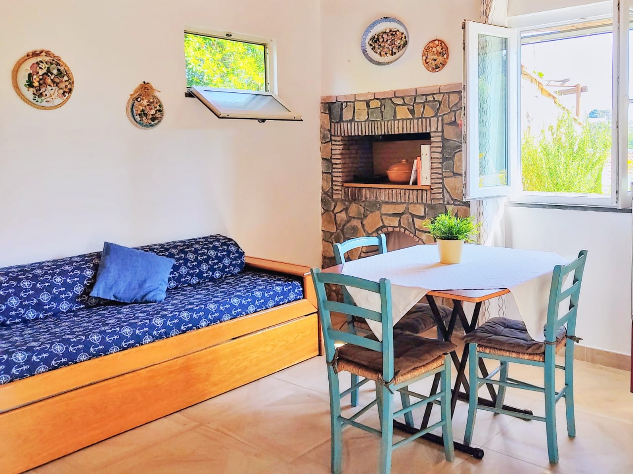 Zona pranzo cucina completa e divano casa vacanze Procida stile mediterraneo